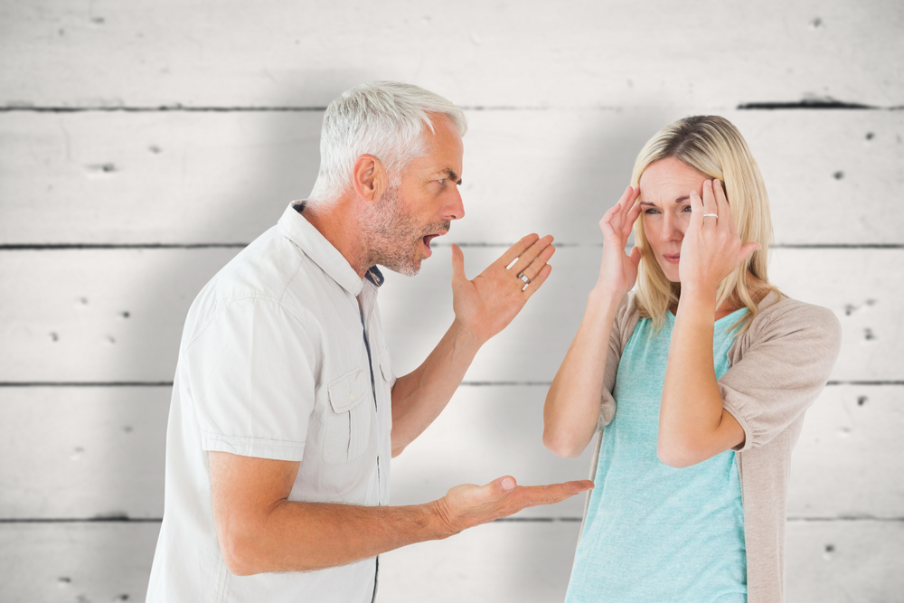 man yelling, woman showing signs of stress.